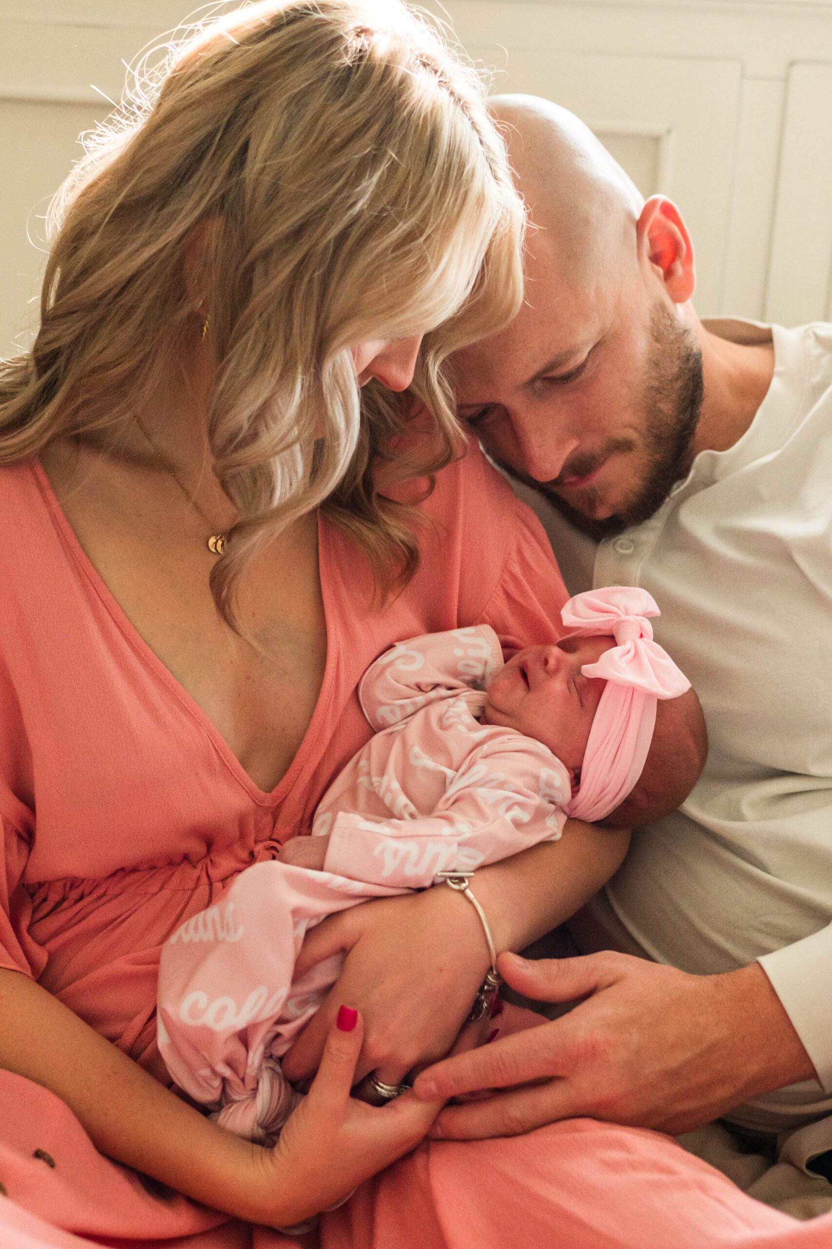 Couple snuggles newborn during in-home session