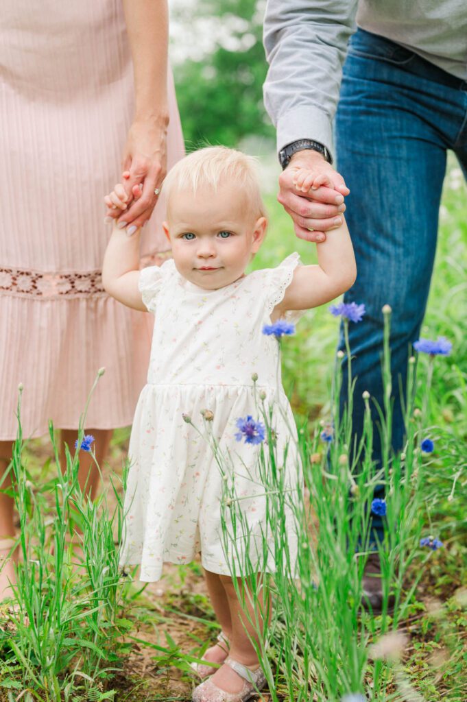 Baby smiles at the camera during a family photoshoot
