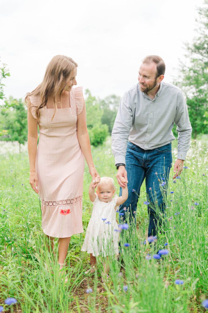 Mom and dad walk with their daughter during their Louisville family photos