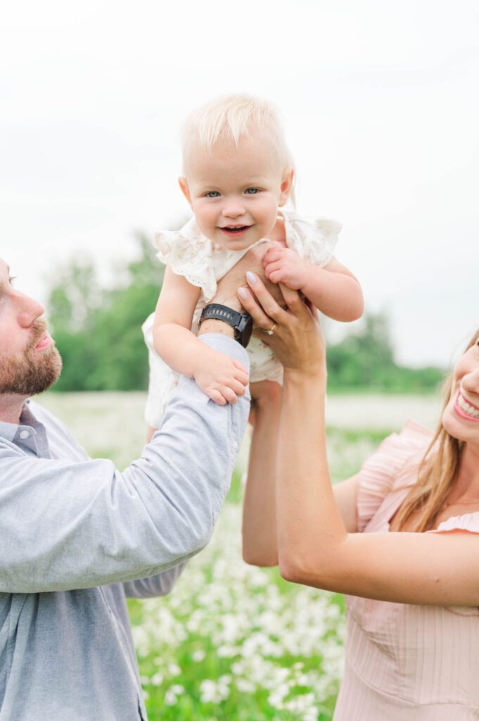 Mom and dad play with baby during their family photos in Louisville