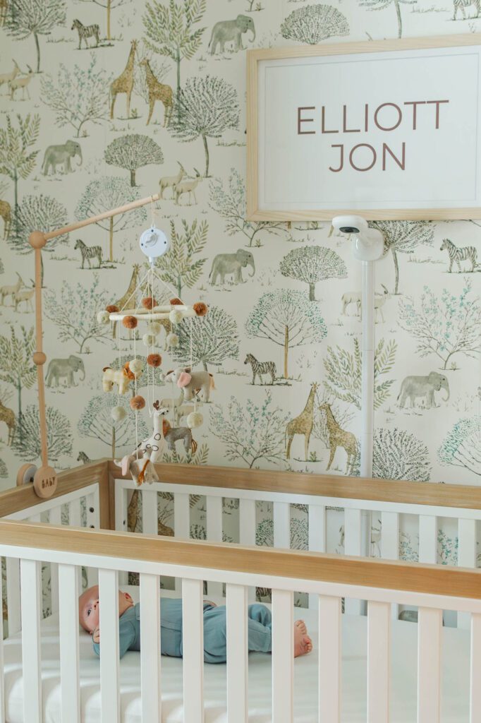 Baby lays in his crib for his 3 month milestone session