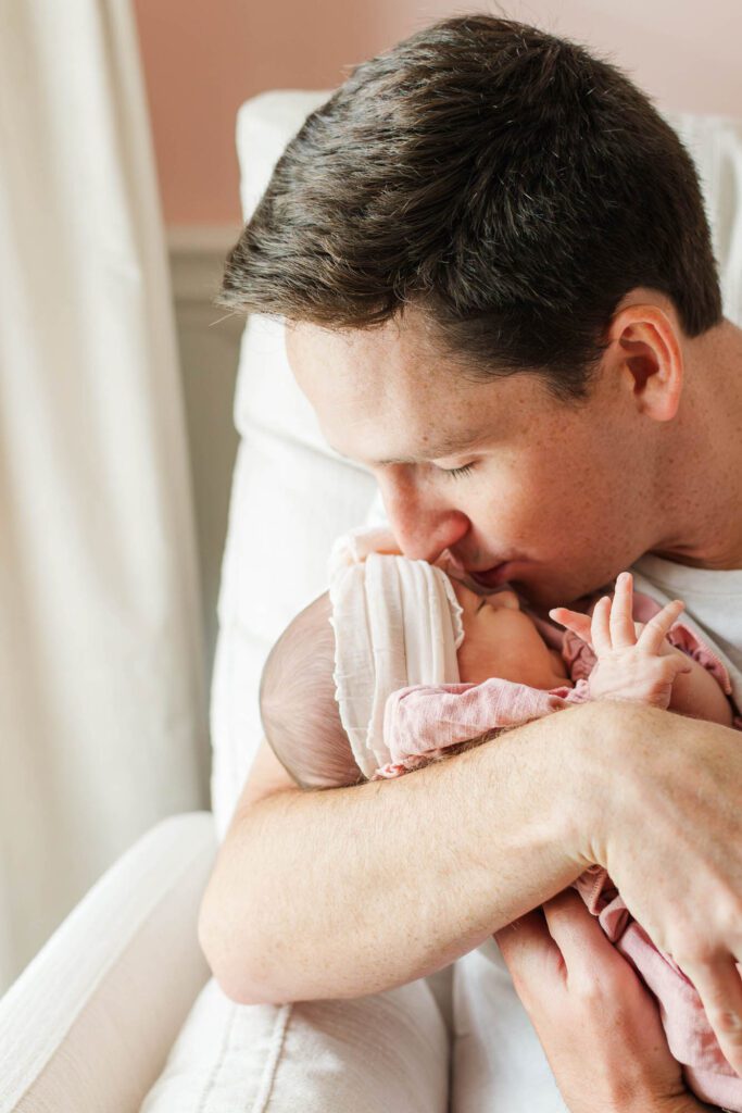 New dad holds his baby girl in the nursery