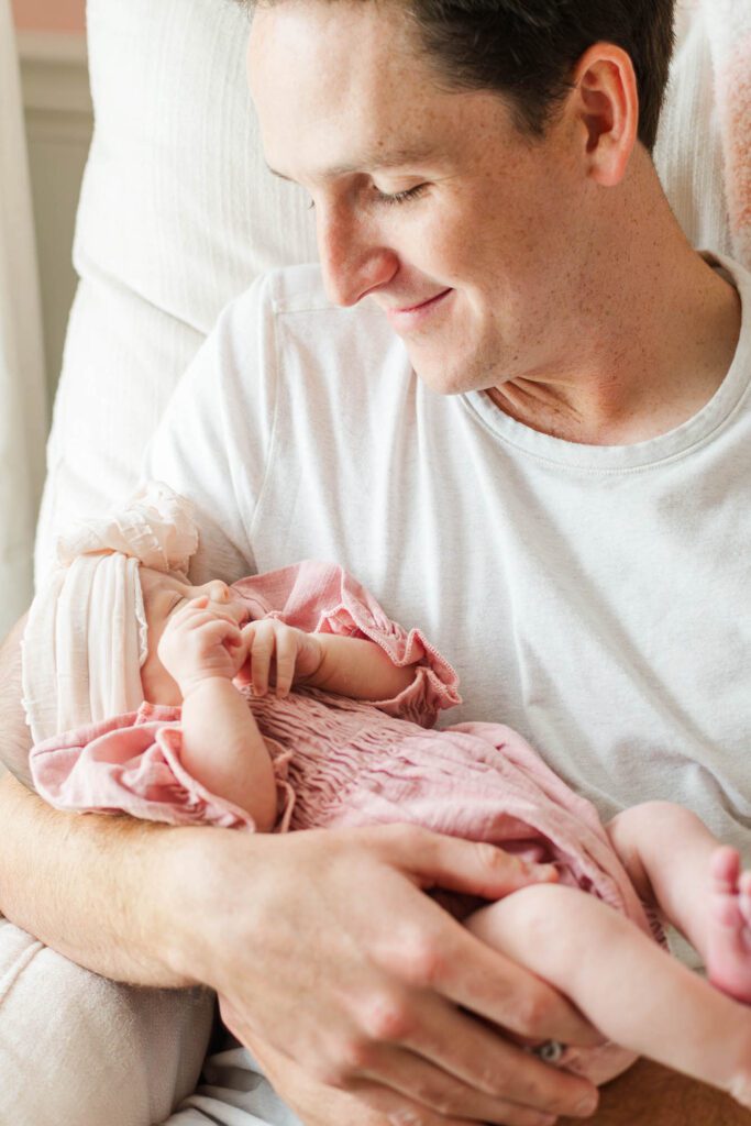 New dad holds his baby girl in the nursery