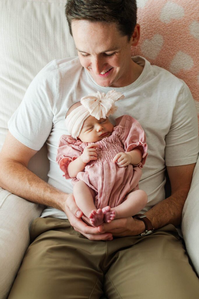 New dad holds his baby girl in the nursery