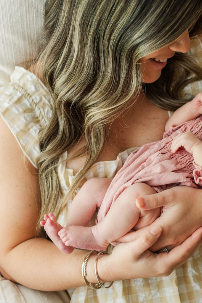 New mom holds her baby girl in the nursery