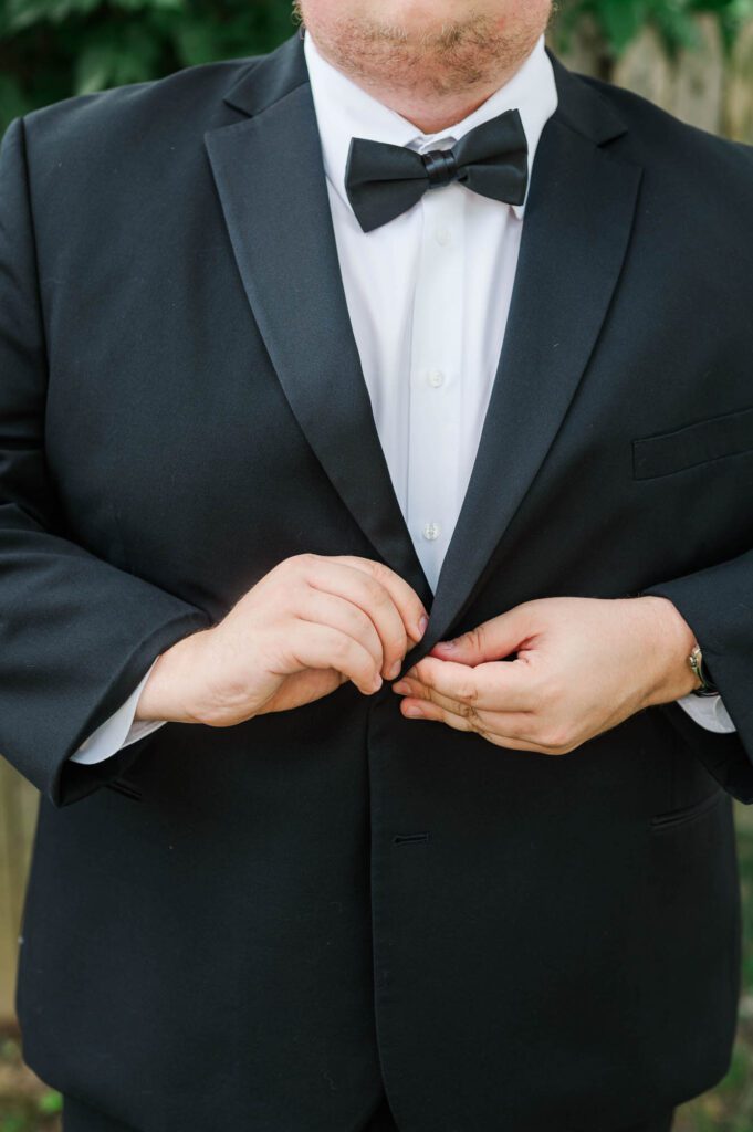 Groom buttoning up his jacket on a wedding day at The Jefferson