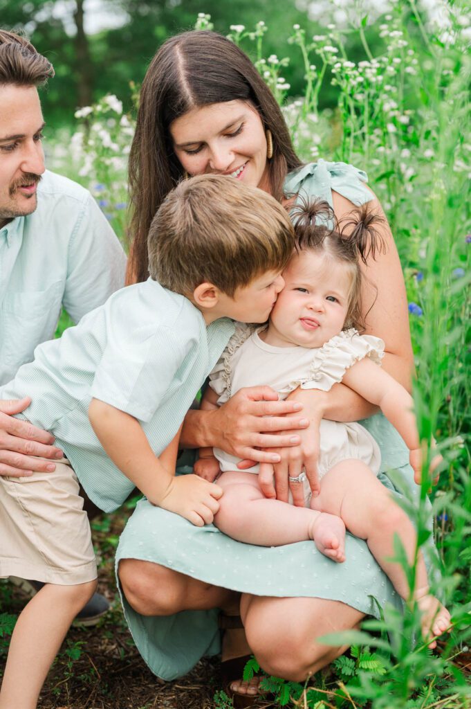 Big brother kisses sister at Beckley Creek Park in Louisville for their photography session