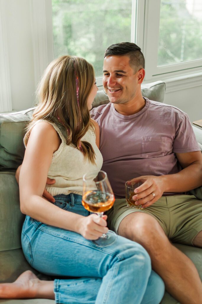 Couple sits together on their couch for their in-home couples session in Louisville, KY