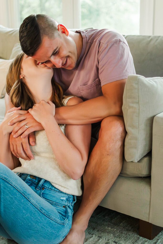 Couple sits together on their couch for their in-home couples session in Louisville, KY
