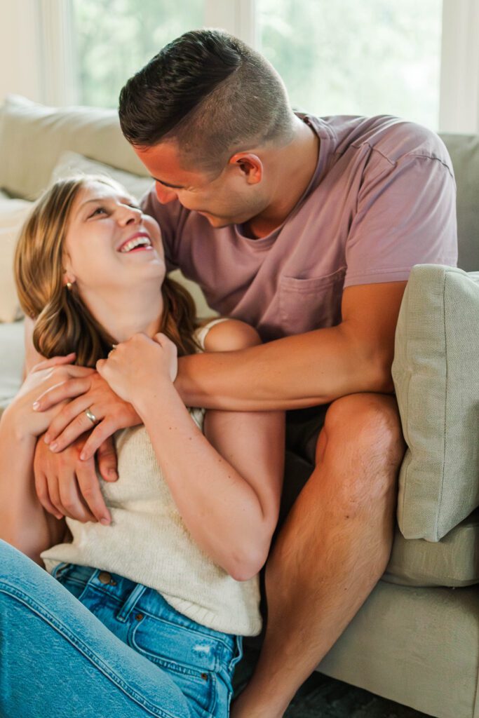 Couple sits together on their couch for their in-home couples session in Louisville, KY