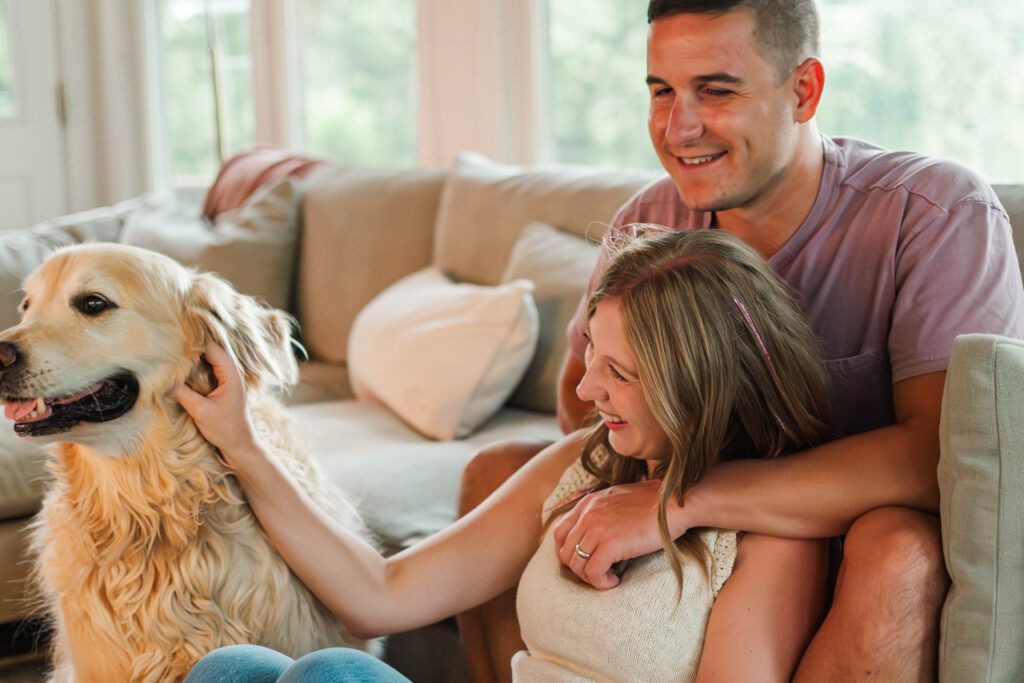 Couple sits together on their couch for their in-home couples session in Louisville, KY