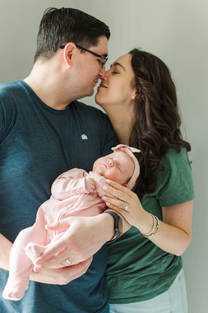 New parents hold their baby girl for their Louisville newborn photography session