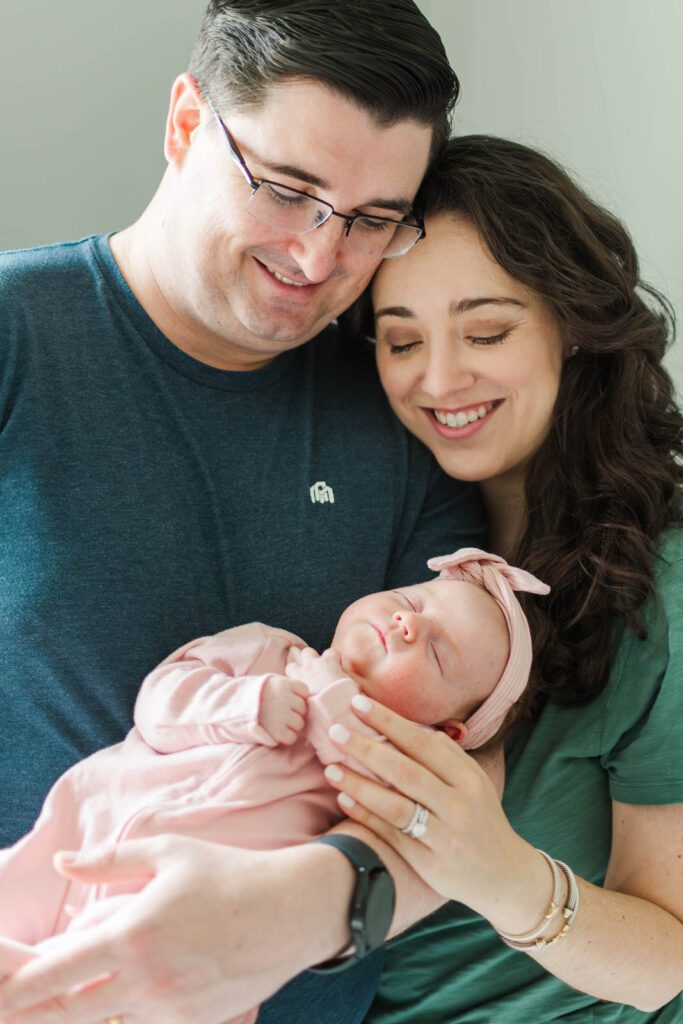 New parents hold their baby girl for their Louisville newborn photography session