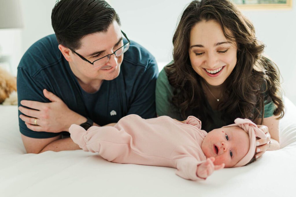 Parents smile down at their newborn baby girl