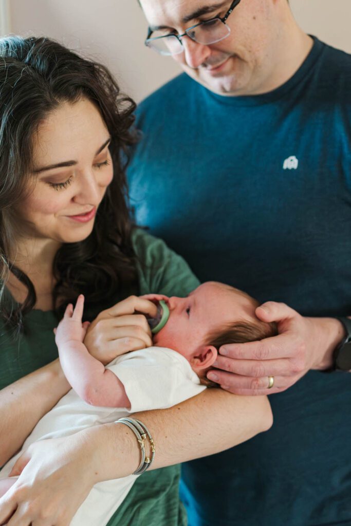New parents hold their baby girl for their Louisville newborn photography session