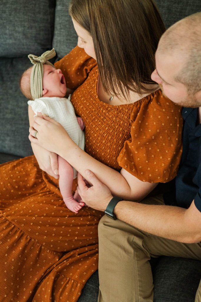 New parents hold newborn during their in-home photography session in Louisville, KY