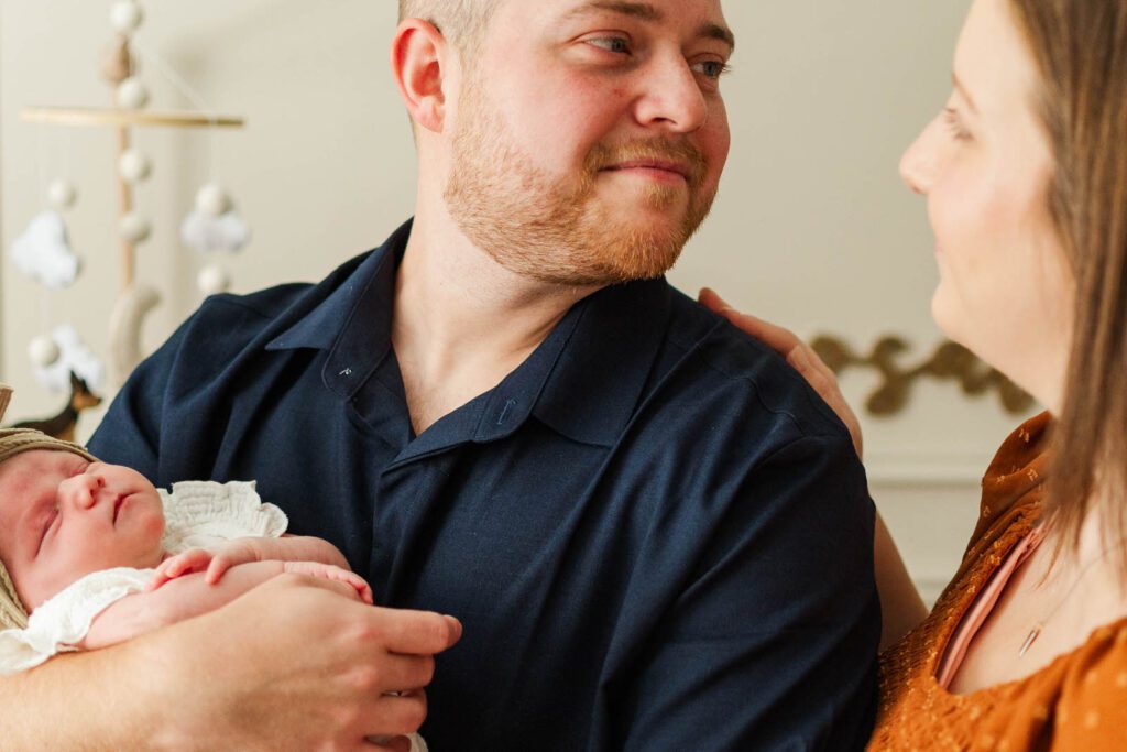 New parents hold newborn during their in-home photography session in Louisville, KY
