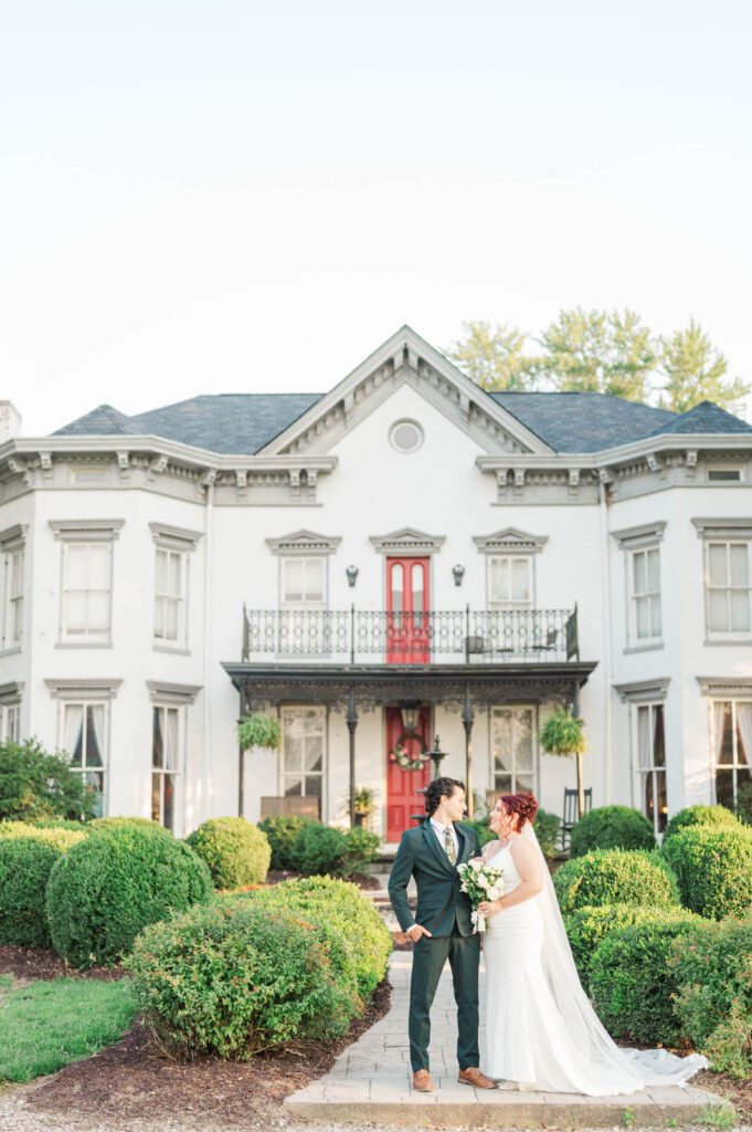 Couple stands in front of Richwood on the River on their wedding day.