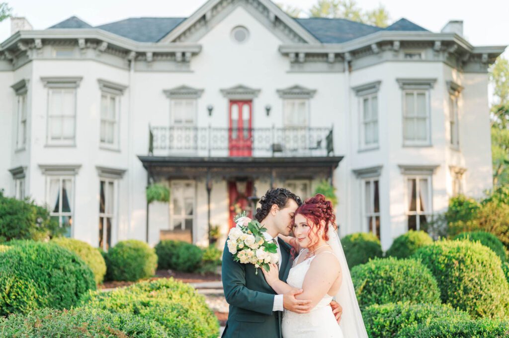 Bride and groom stand in front of Richwood on the River