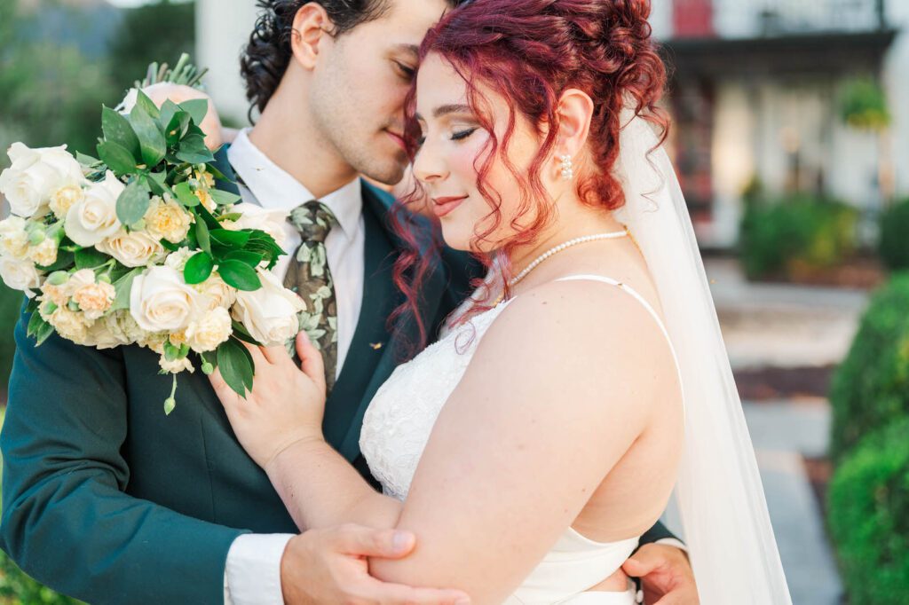 Bride and groom stand in front of Richwood on the River