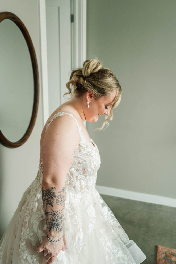 Bride revealing her dress to her bridesmaids and family