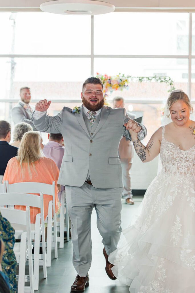 Bride and groom celebrate down the aisle after getting married at the Ice House in Louisville