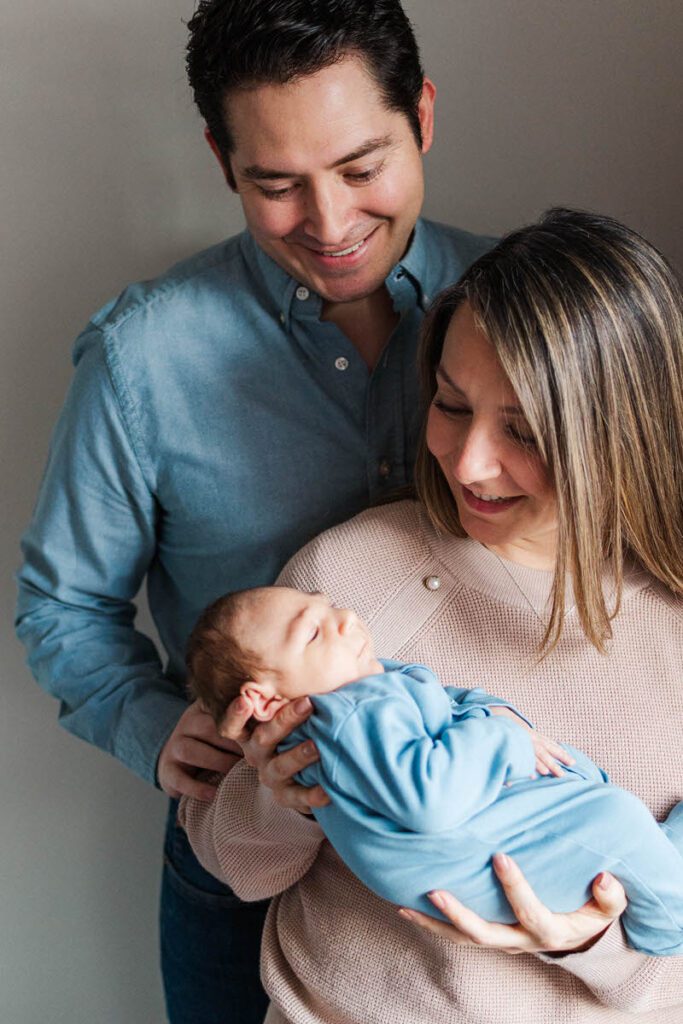 Mom and dad hold baby during their Louisville in-home newborn session.