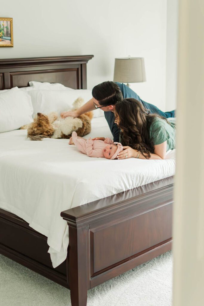 A mom and dad lay on bed with newborn baby, dad playing with their pup. 

A black and white image of a small family with their newborn baby and toddler.

Louisville In-Home Newborn Photographer

Michelle Bordenkircher Photography