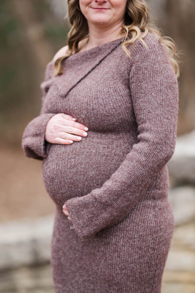 A mom to be places her hands on her belly during her winter maternity session at Anchorage Trail.
Michelle Bordenkircher Photography