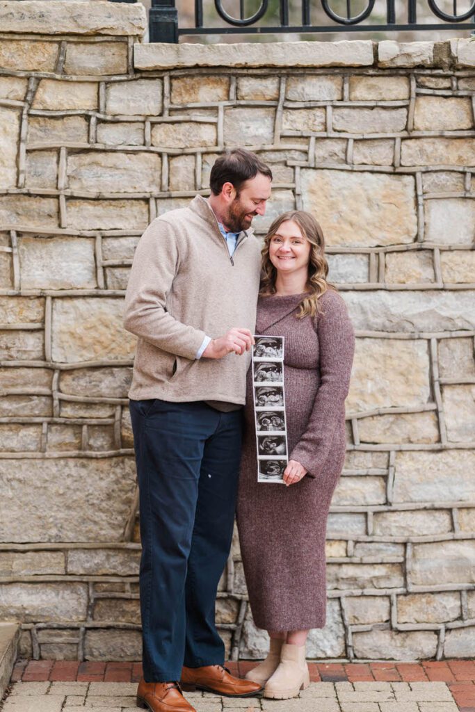 A mom and dad to be show off a strip of photos from an ultrasound at an Anchorage Trail maternity session.
Michelle Bordenkircher Photography