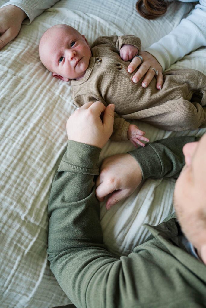 A dad looks down proudly at his baby boy during his Louisville In-Home newborn session
Photos by Michelle Bordenkircher Photography
