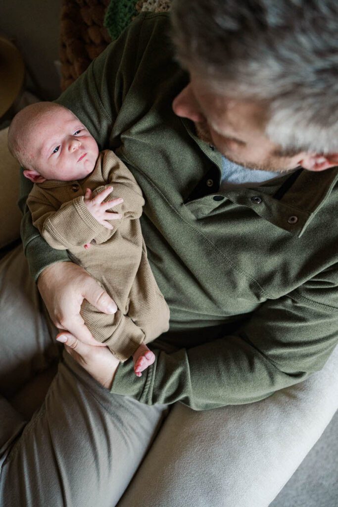 A dad smiles down at his baby boy during their Louisville In-Home newborn session
Photos by Michelle Bordenkircher Photography