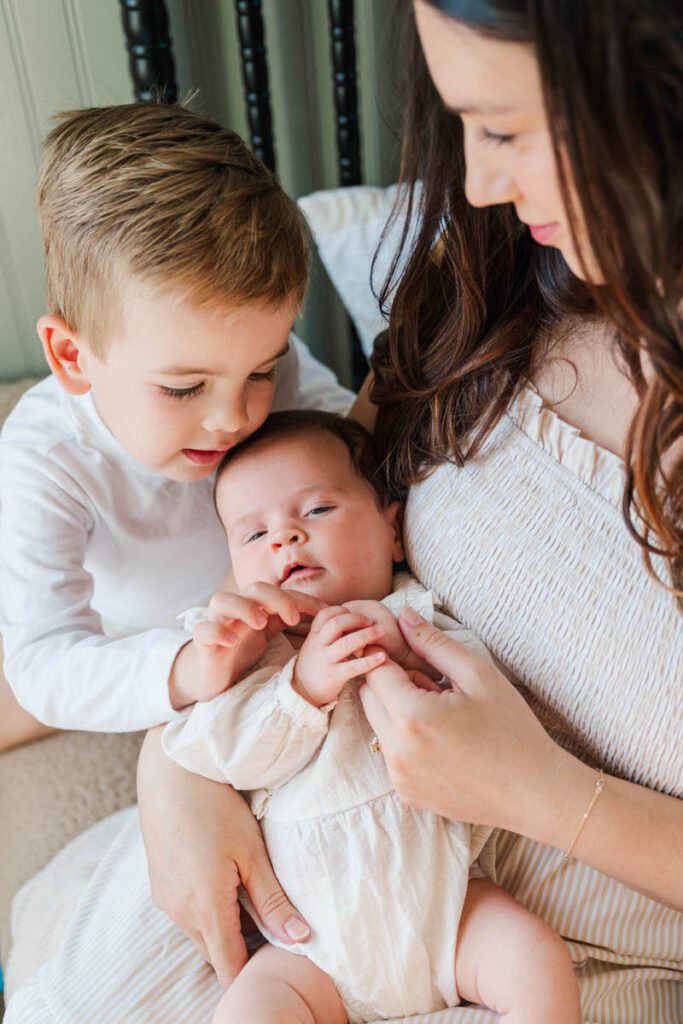 A mom and dad smile at their new baby boy during their Louisville In-Home newborn session Photos by Michelle Bordenkircher Photography