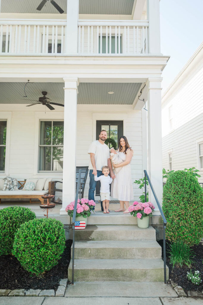 Louisville family take a picture outside of their home for their in-home newborn session
