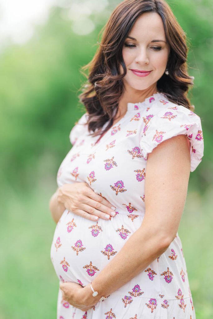 An expectant mama smiles at Beckley Creek Park in Louisville for her summer maternity session.