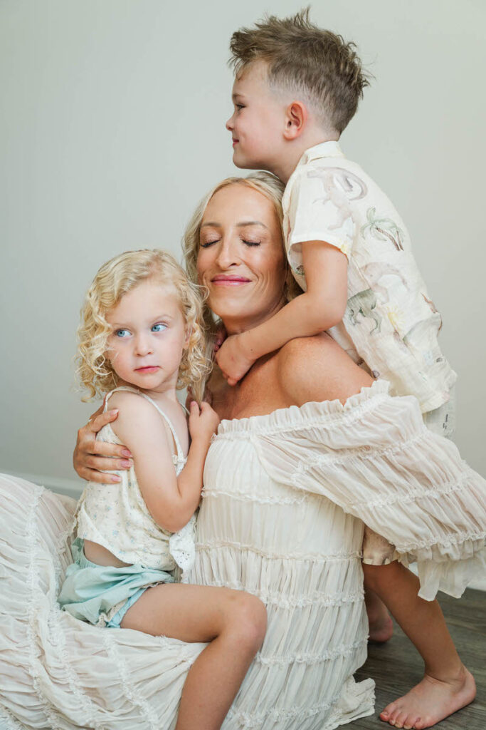 Mom snuggles her kids during their Louisville in-home maternity session.