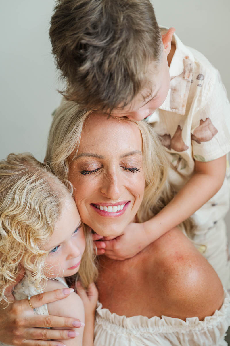 Mom snuggles with her kids during her Louisville in-home maternity session.