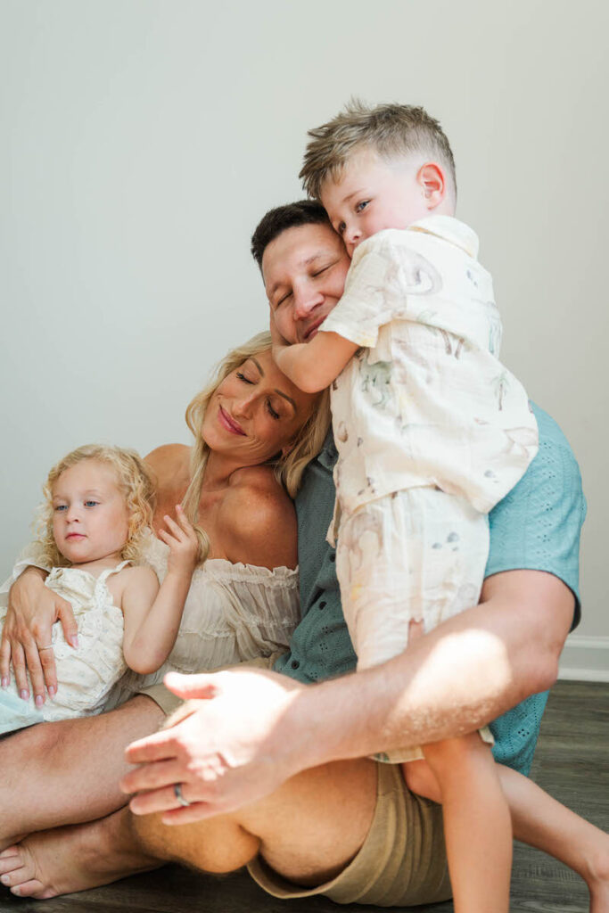 An expecting family snuggles with their kids during their Louisville maternity session.