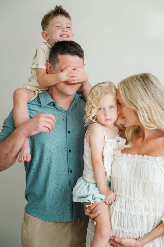 An expecting family plays with their kids during their Louisville maternity session.