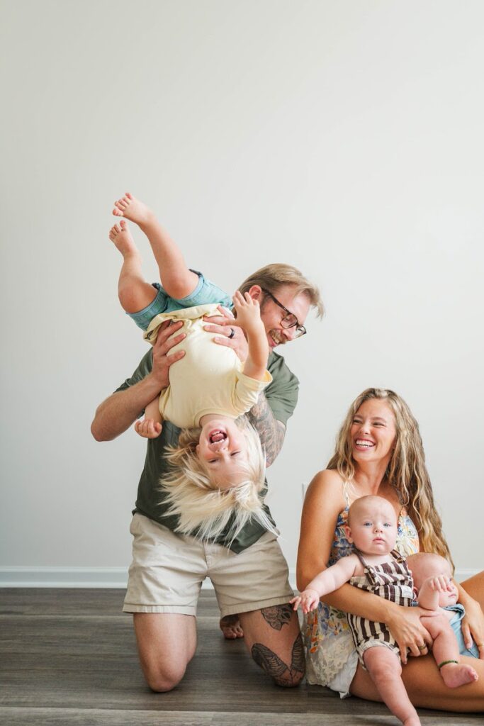 Dad turns toddler upside down and laughs during their Louisville in-home photos.