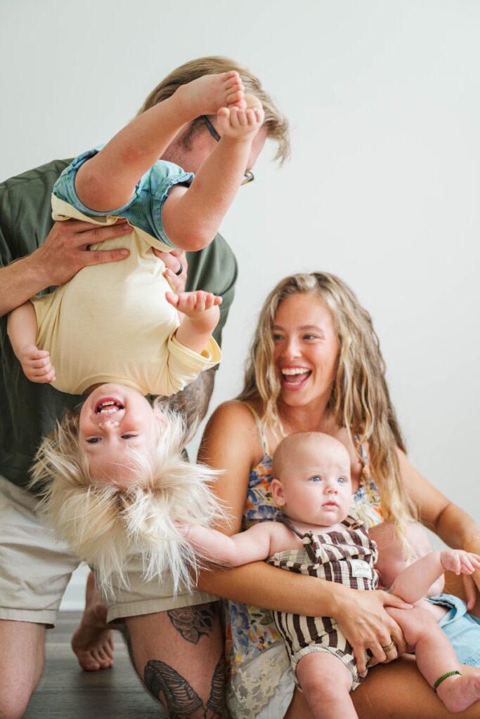 Dad turns toddler upside down and laughs during their Louisville in-home photos.