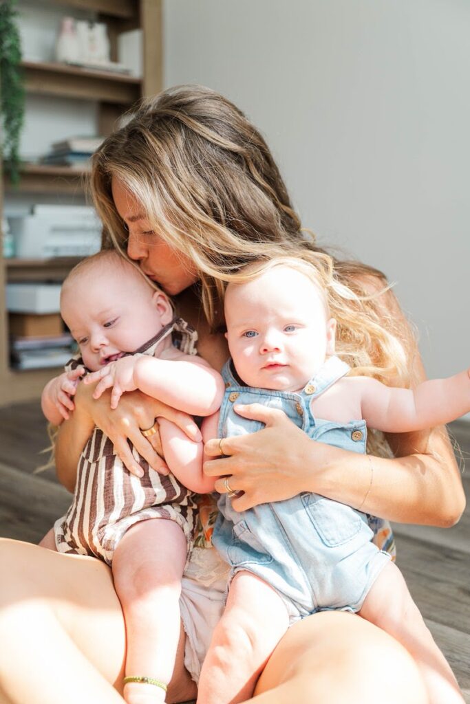 Mom kisses her twin boys during her Louisville in-home family photos.