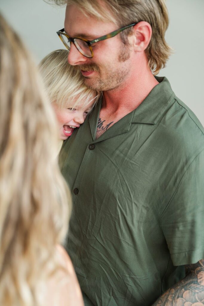 Toddler laughs in his dad's arms during their in-home photo session.