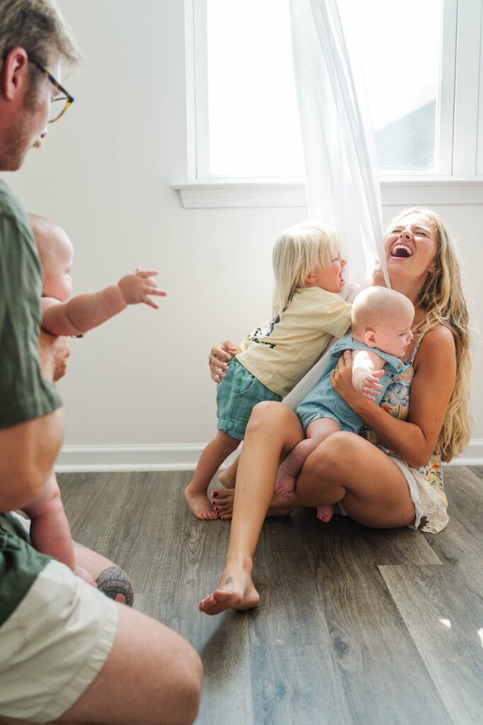 Toddler son runs and gives his mom a hug and they laugh during their Louisville in-home family photos.