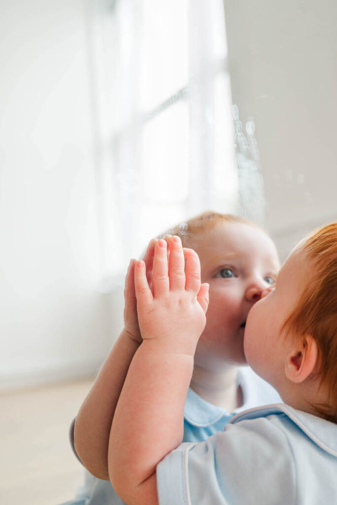 Baby give his reflection a kiss in the mirror for his Louisville six month photos.