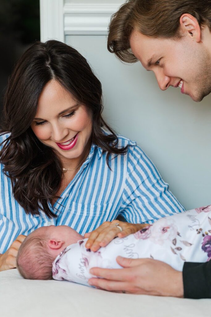 Mom and dad smile down at their new baby girl during their Louisville newborn session.