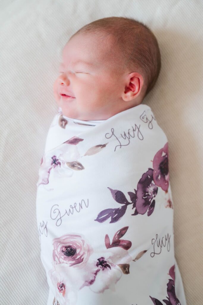 Close-up picture of newborn baby girl smiling during her newborn session.