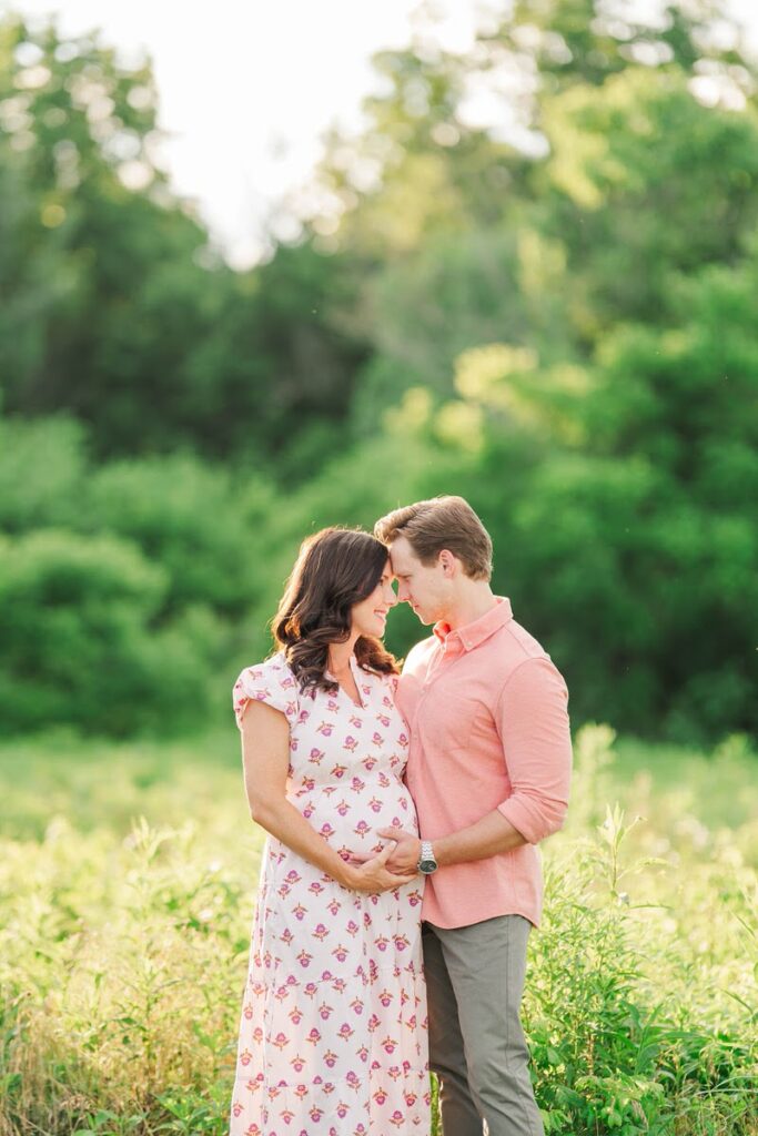 An expecting mom and dad share a private moment in the sunlight during their maternity session at Beckley Creek Park in Louisville.
