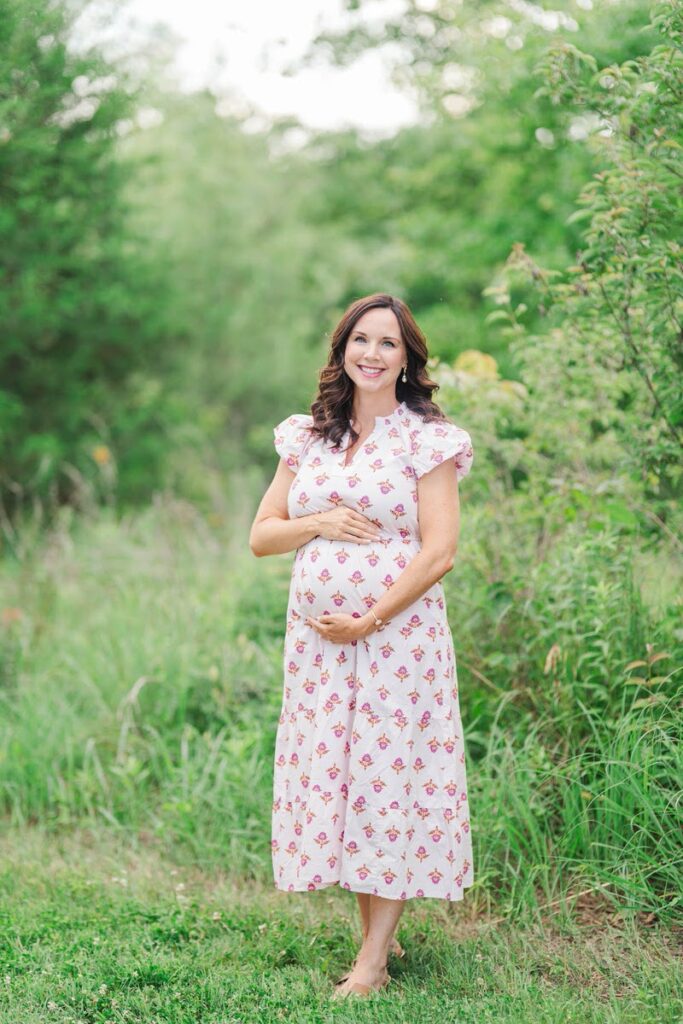 Expecting mom smiles and holds her baby bump during her Louisville maternity session.