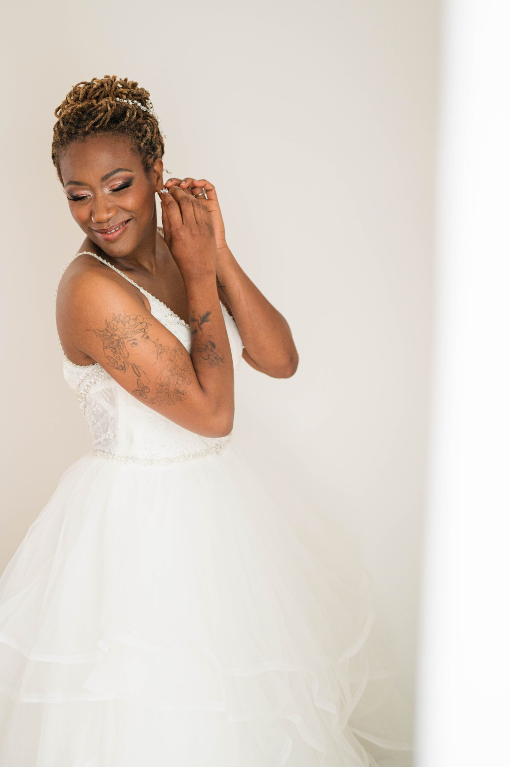 Bridal getting ready shot - bride puts in earrings on her wedding day